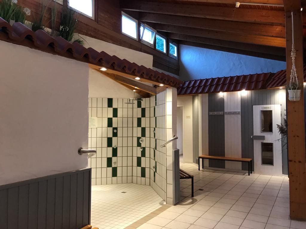 Ein Badezimmer mit Dusche und einer Sitzbank darin