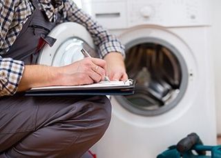 Repairman Writing on a Paper — The Other Guy Appliance Repair in Kansas City, KS Repairman Writing on a Paper — The Other Guy Appliance Repair in Kansas City, KS