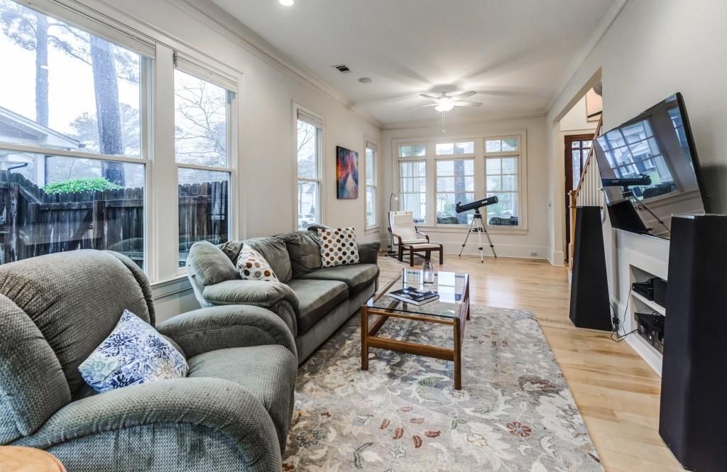 A living room with a couch , chairs , and a television.