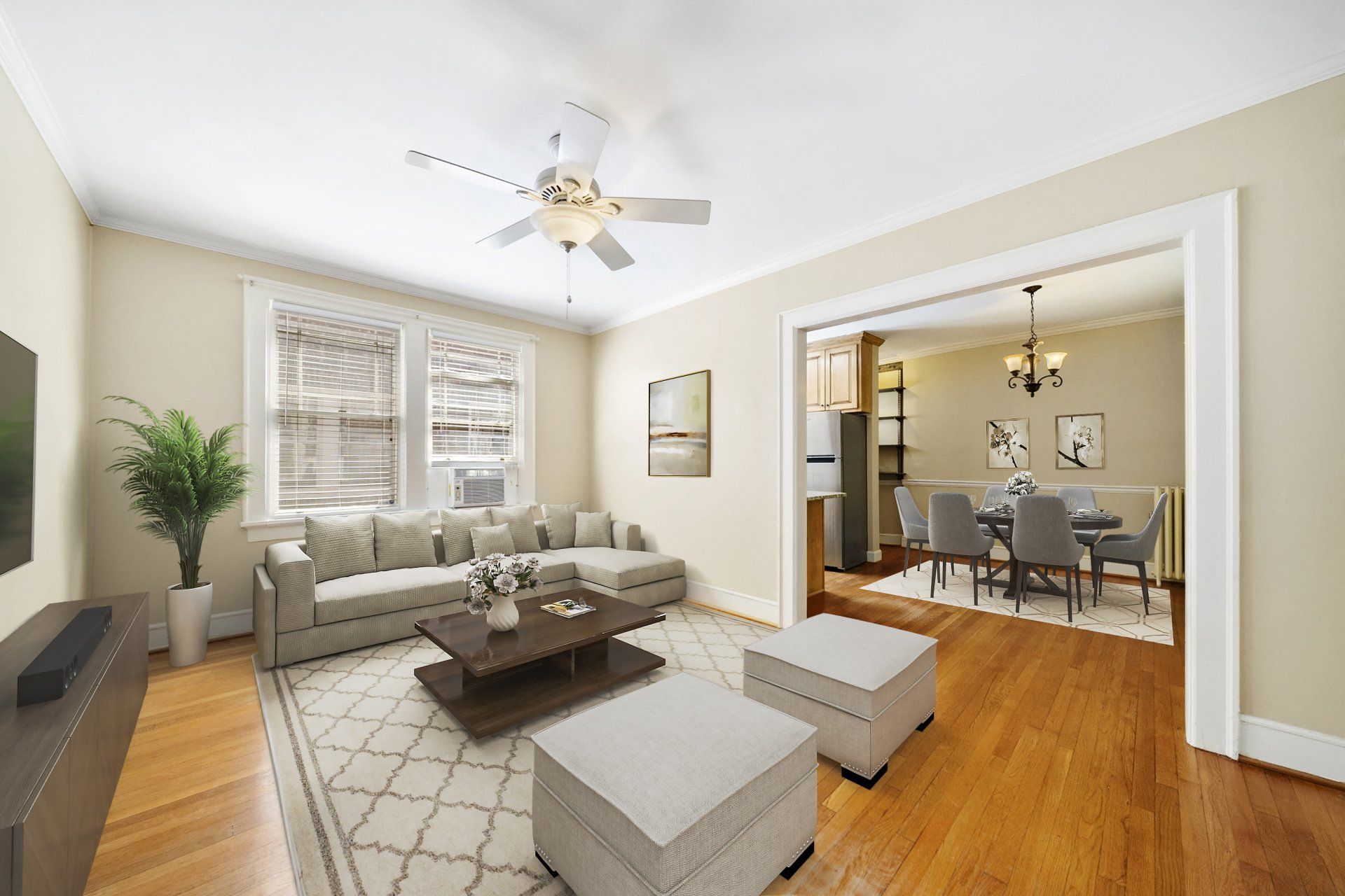 A living room with a couch , coffee table , ottomans and a ceiling fan.