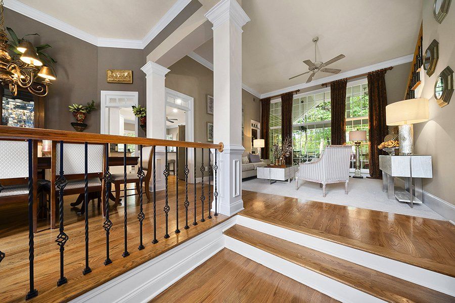 A living room with hardwood floors and stairs leading up to it