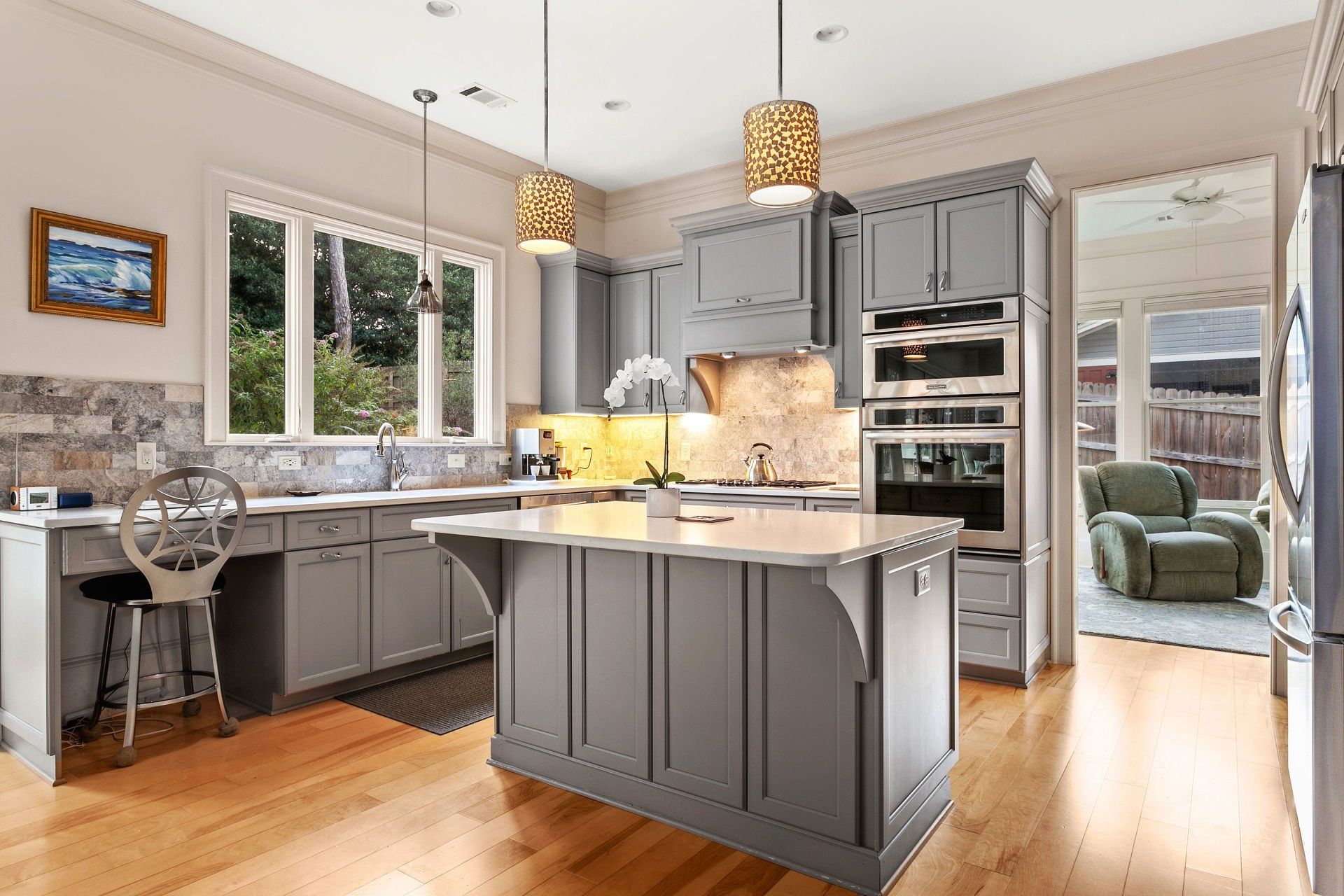 A kitchen with gray cabinets and a large island in the middle.