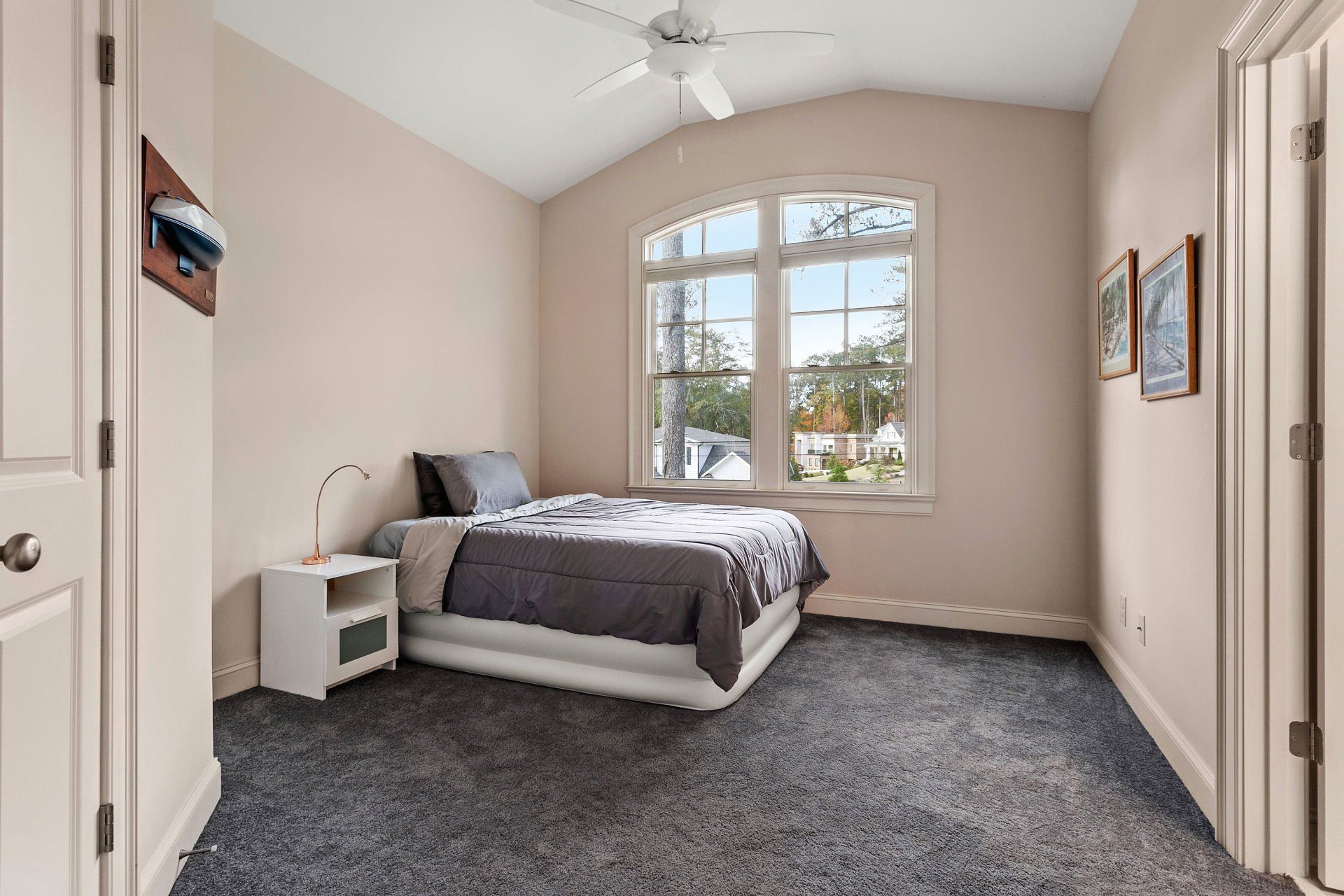 A bedroom with a bed , nightstand , and ceiling fan.