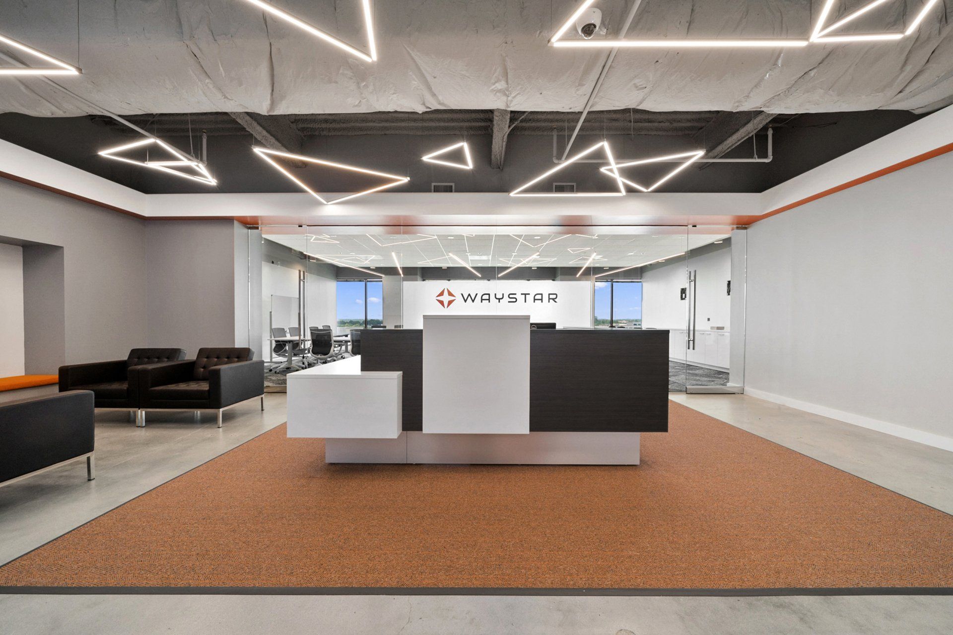 A large room with a reception desk and chairs in it.