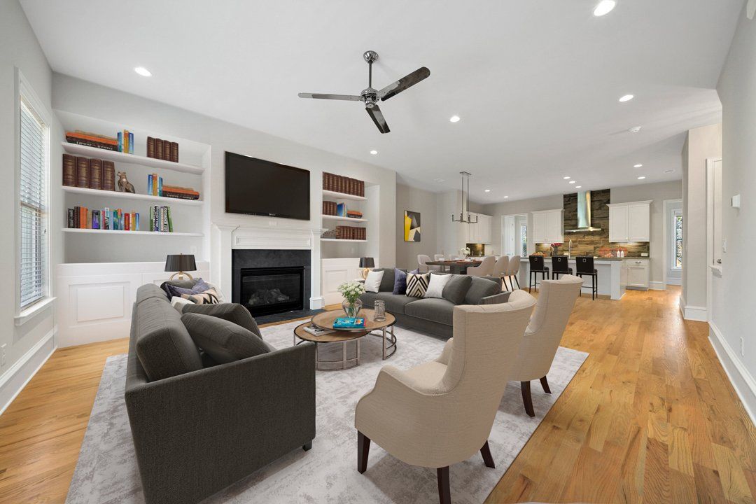 A living room filled with furniture and a fireplace with a ceiling fan.