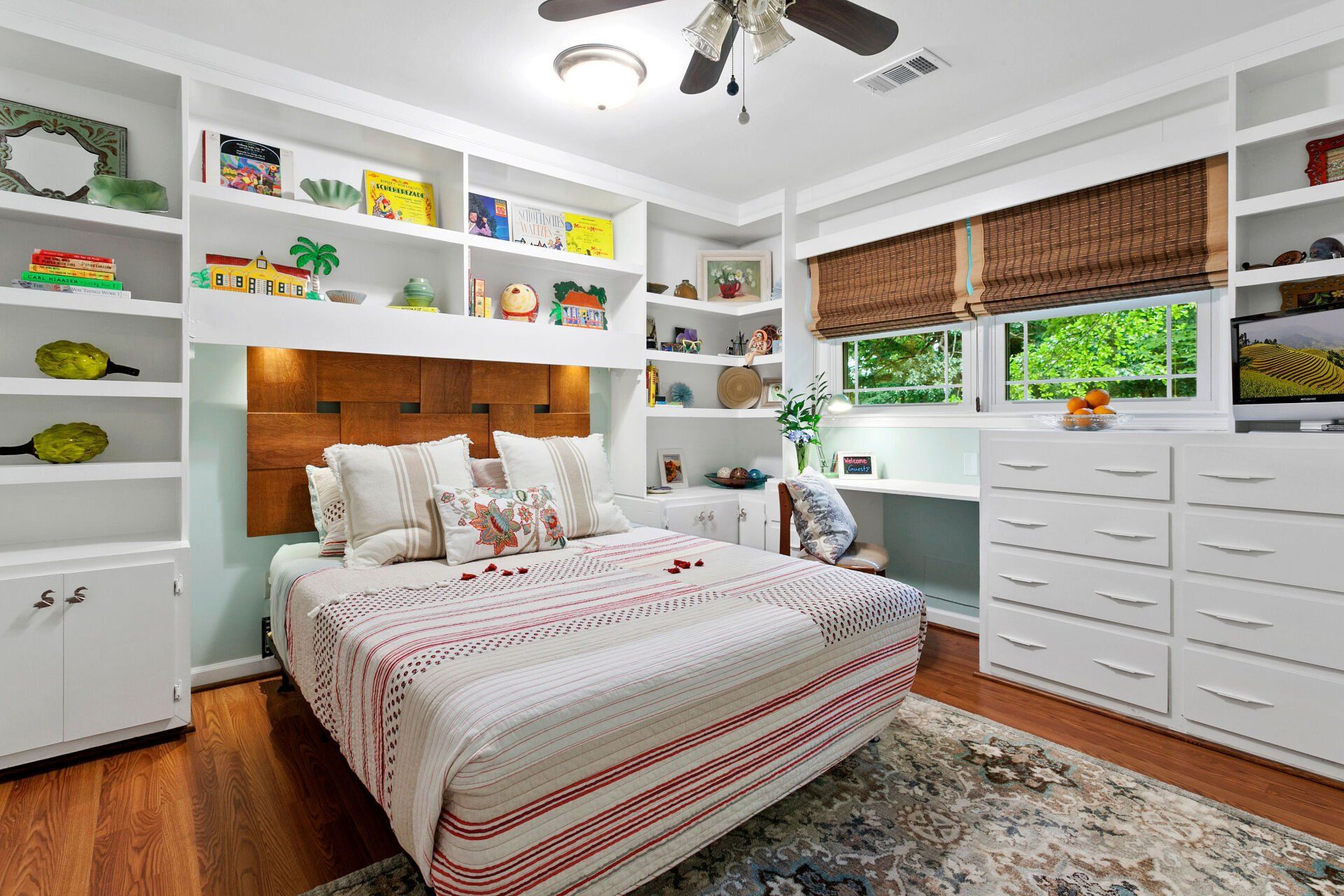 A bedroom with a large bed and a ceiling fan