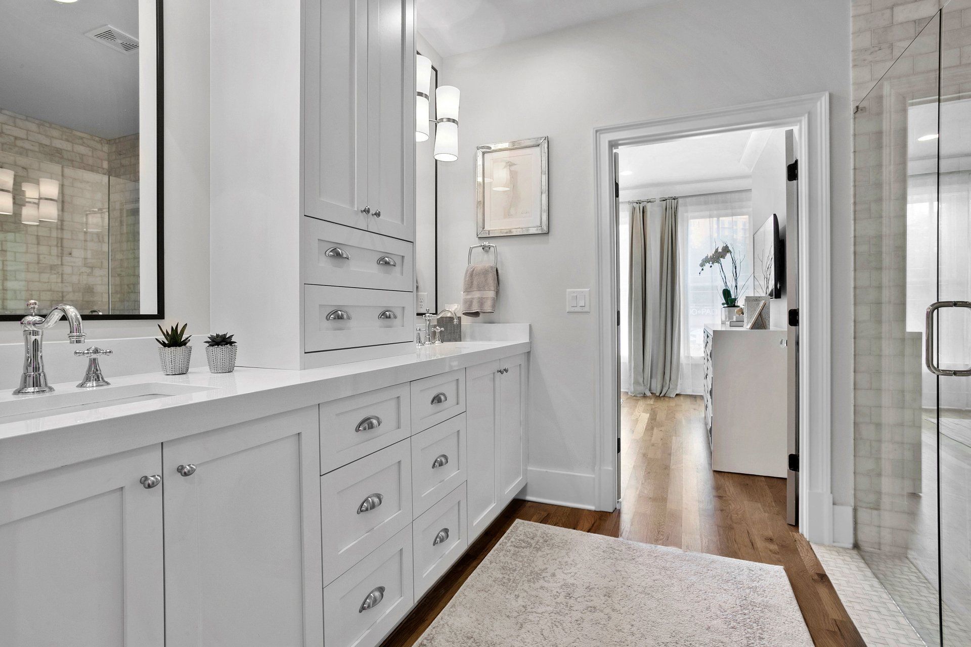 A bathroom with two sinks and a walk in shower.