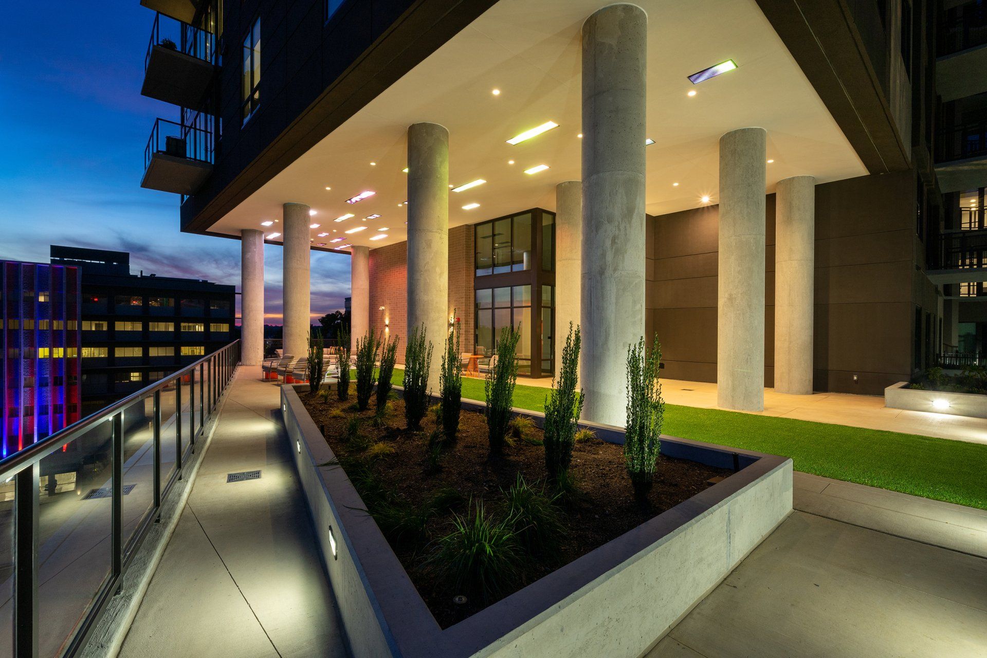 A large building with a lot of columns and plants in front of it