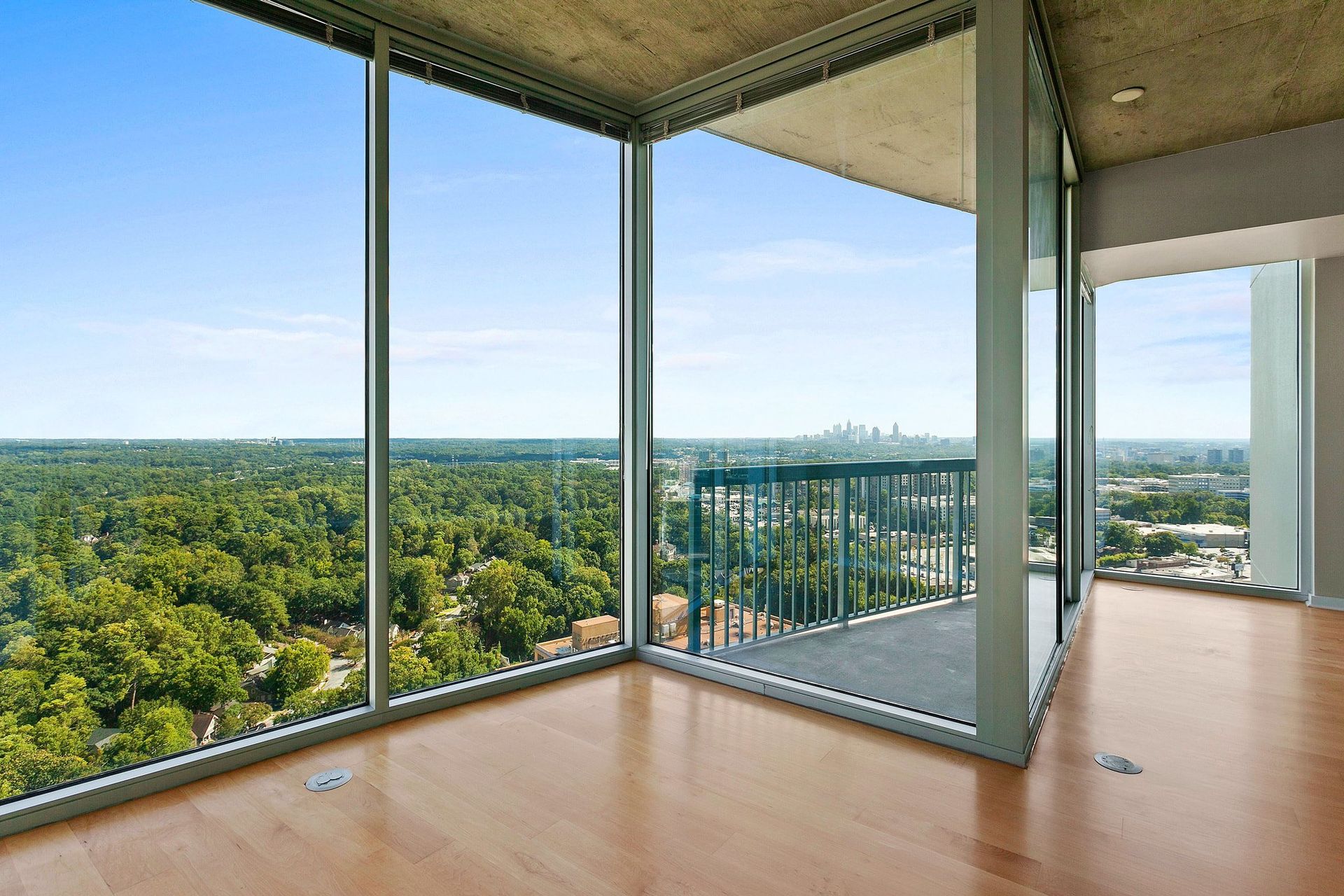 An empty room with a balcony and lots of windows