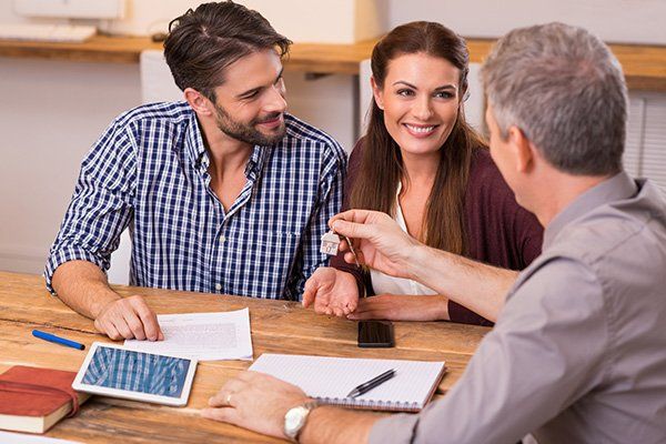 A couple receives keys from their rental agent.