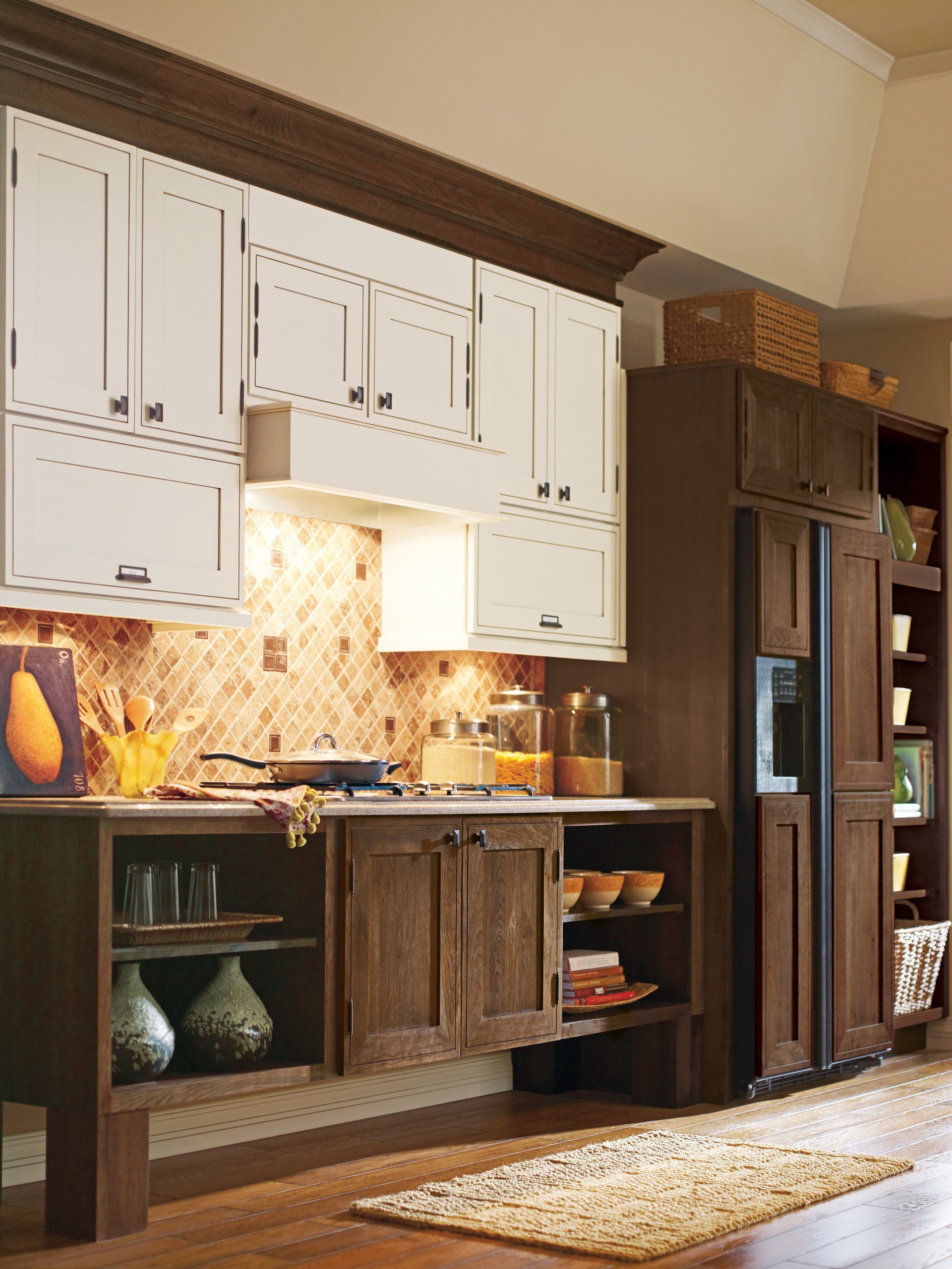 Modern kitchen with white cabinets, dark wood lower cabinets, a mosaic backsplash, and a rug on the floor