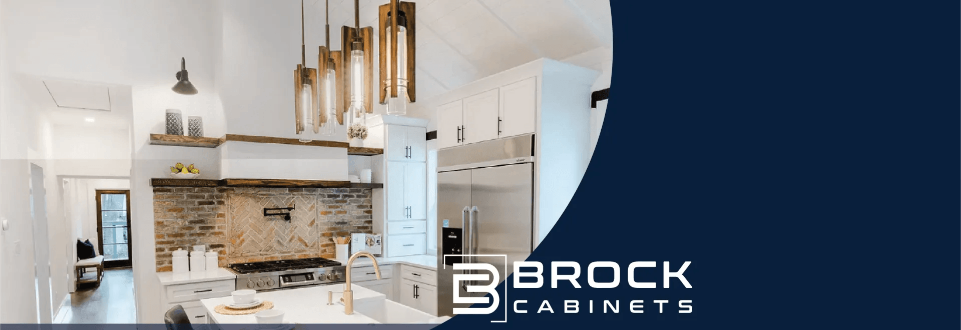 Modern white kitchen with stone backsplash and wood pendant lights, featuring Brock Cabinets branding