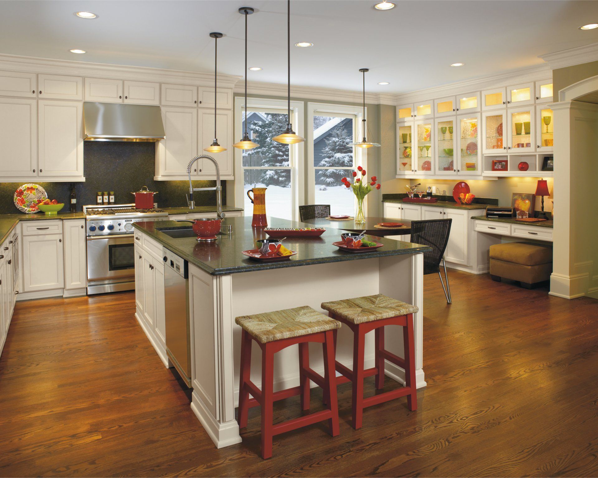Bright modern kitchen with island, stools, stainless appliances, and warm hardwood floors