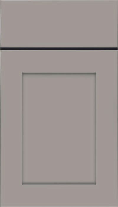 Close-up of a muted green cabinet door with a recessed rectangular panel.