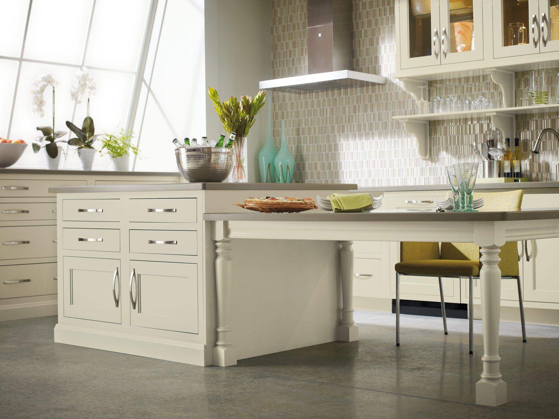 Modern kitchen with a white island, potted plants, and open shelves with glassware