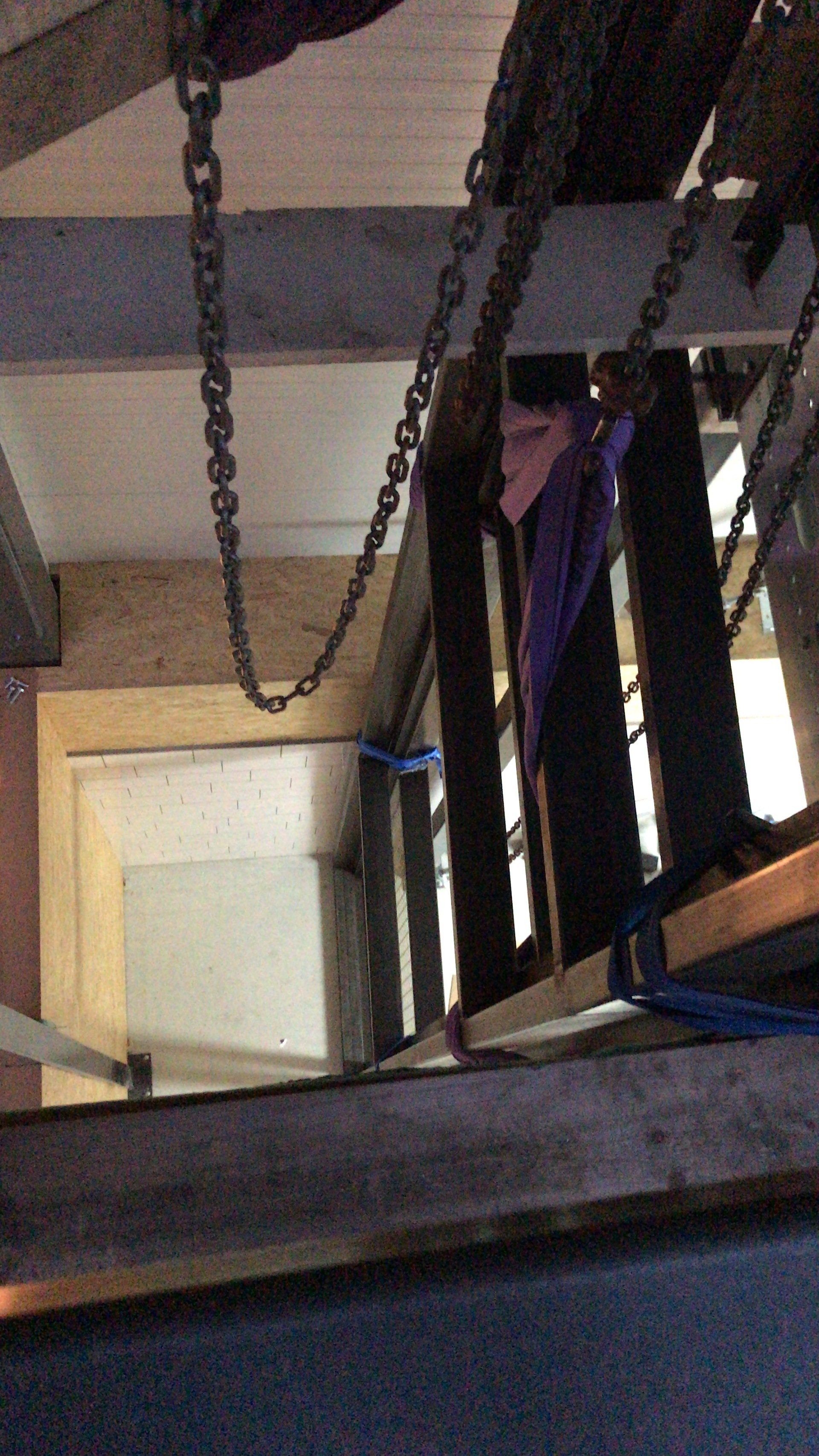Uitzicht vanaf een houten toren waaraan kettingen hangen.