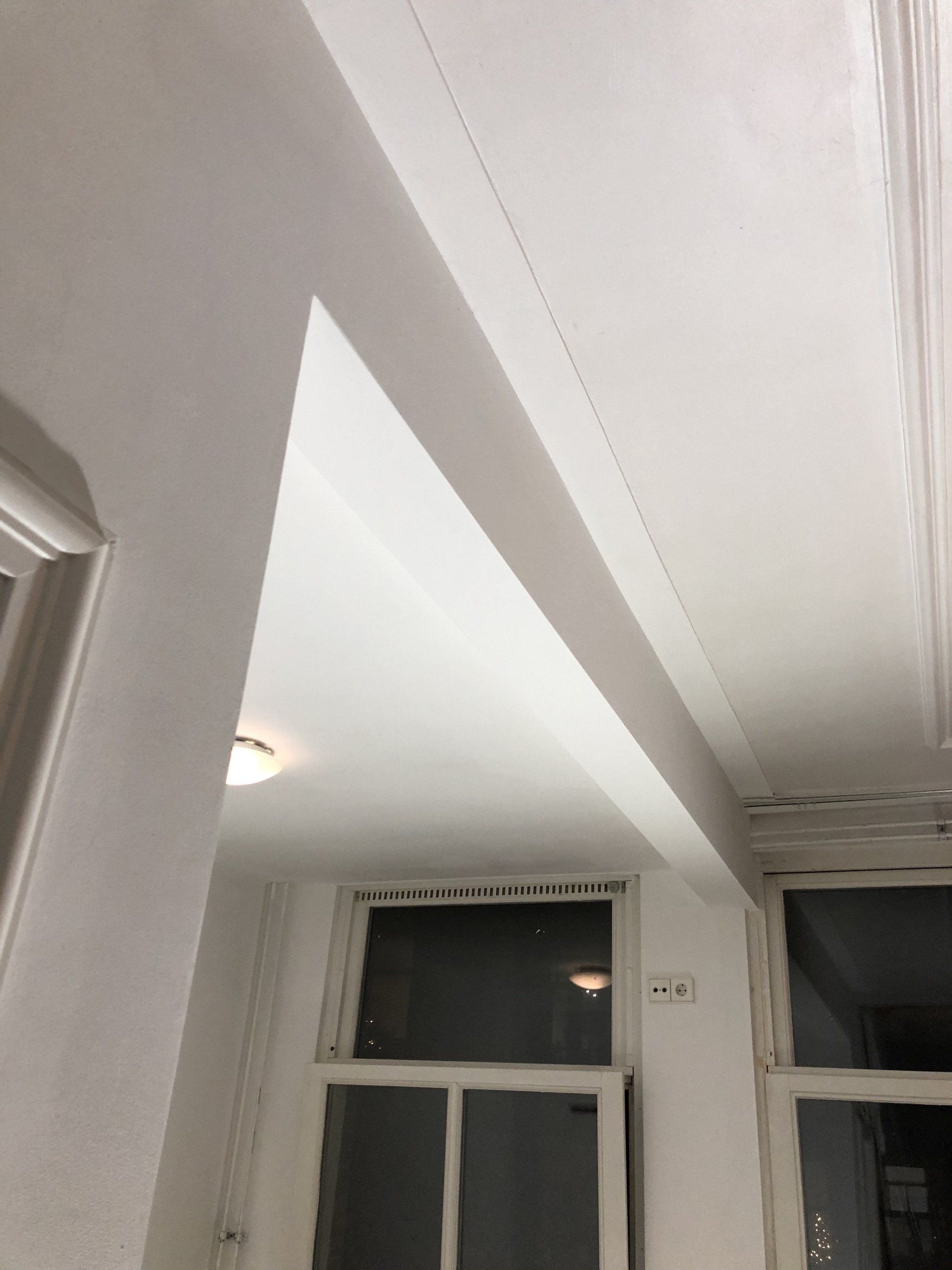 Wit plafond met een verzonken balk. Twee ramen eronder.