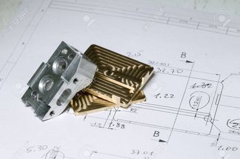 A couple of metal pieces sitting on top of a drawing.