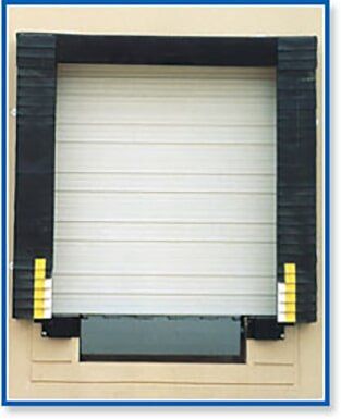 Closed white roll-up loading dock door with black side panels and yellow bumpers