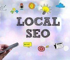 A person is holding a cell phone in front of a sign that says `` local seo ''.