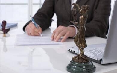Scale of Justice and a Lawyer Writting on Paper — Law Firm in Brownstone, IN