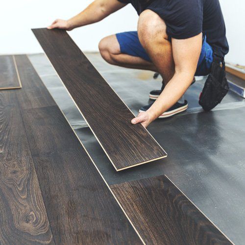 Residential Flooring — Man Placing Hardwood Floor in Muscle Shoals, AL Residential Flooring — Man Placing Hardwood Floor in Muscle Shoals, AL