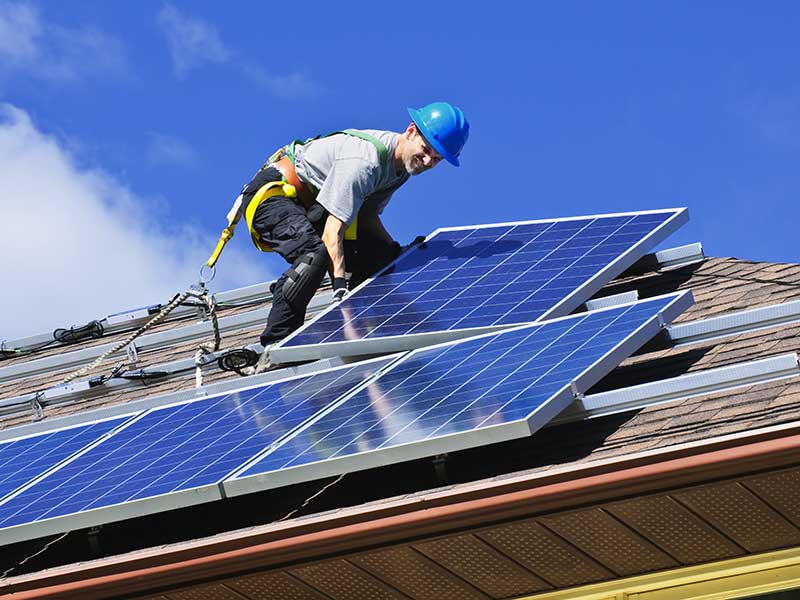 tecnico mentre installa dei pannelli solari