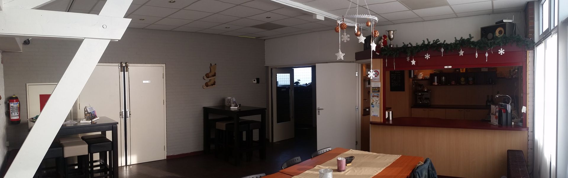 Interior view of a room, possibly a cafe, with a counter, tables, and decorative accents.