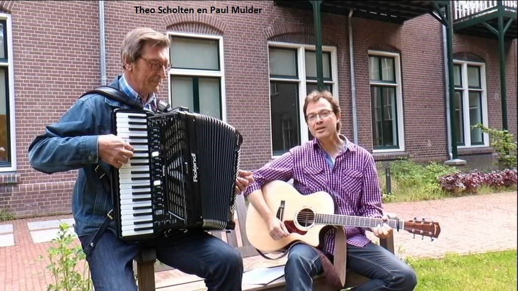 Two men playing music outdoors: accordion and guitar.