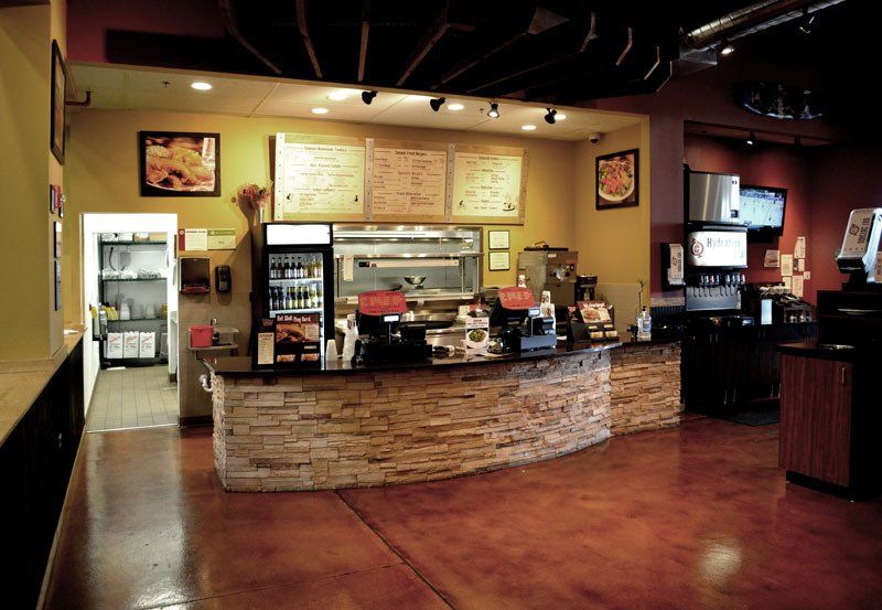 A restaurant with a brick counter and a cooler
