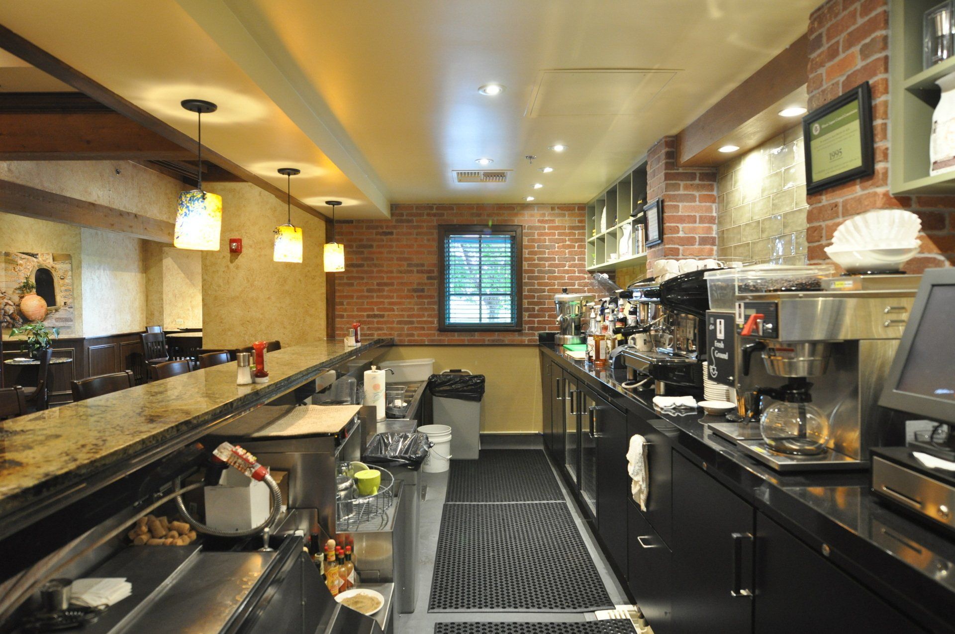 A kitchen with a lot of appliances and a brick wall