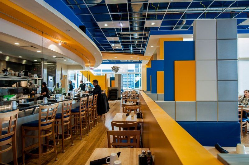A restaurant with blue and yellow walls and tables and chairs