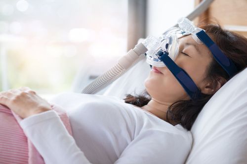 Woman Using CPAP Machine — Fort Myers, FL — Children & Adult Dentistry Woman Using CPAP Machine — Fort Myers, FL — Children & Adult Dentistry