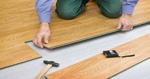 someone laying laminate flooring