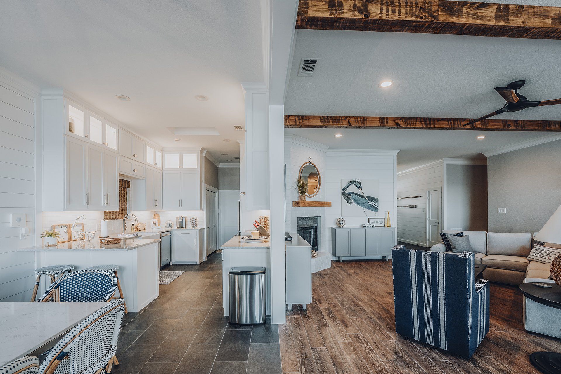 A living room and kitchen in a house with a ceiling fan.