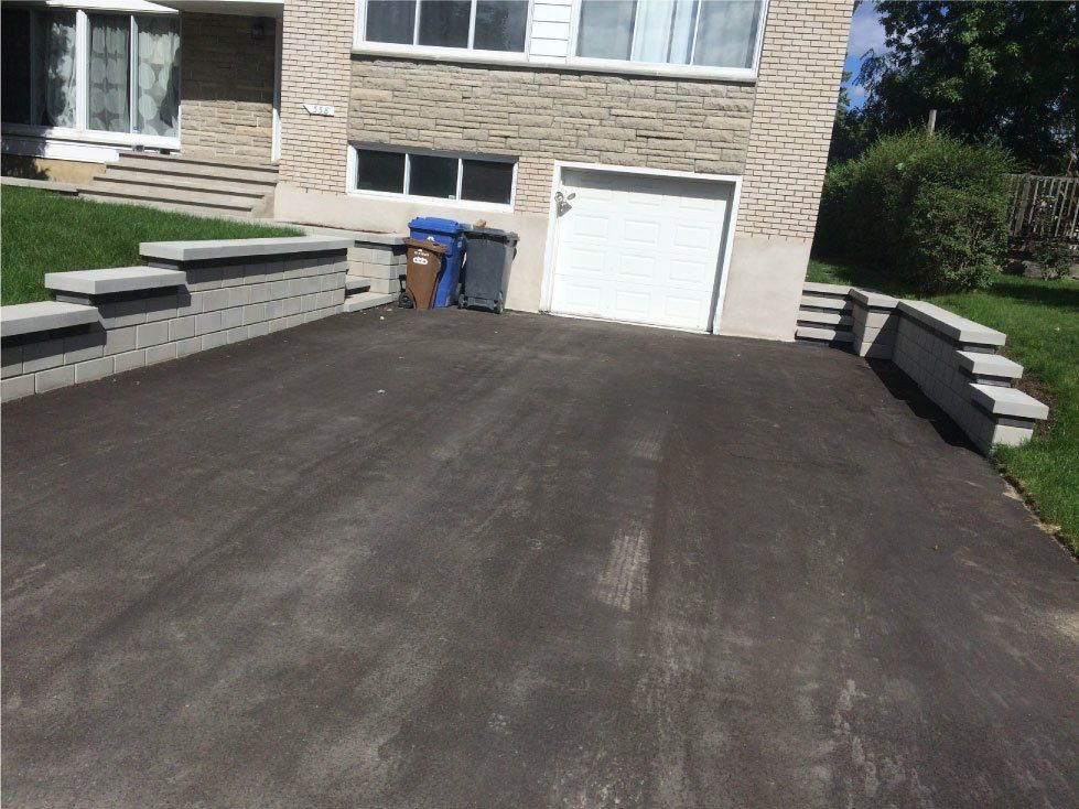driveway with white garage and black asphalt