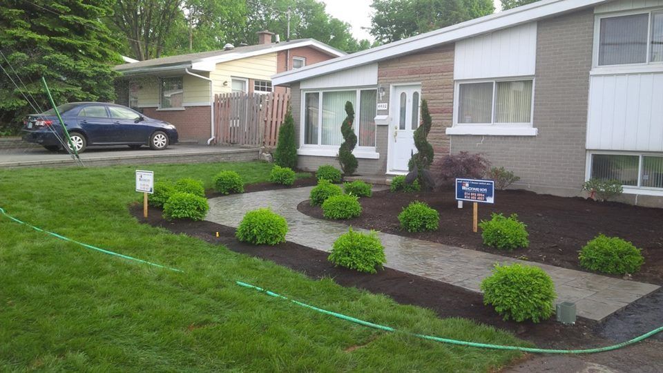front yard with green grass and unistone walkway
