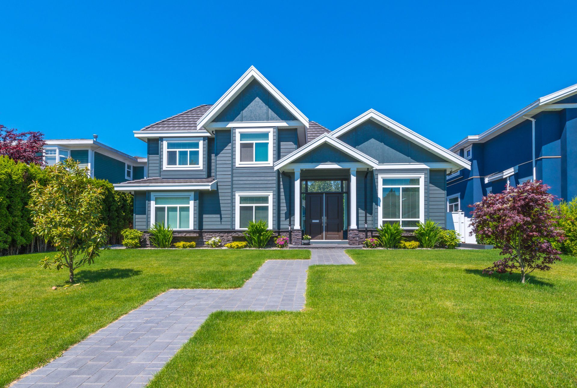 large blue house with green grass