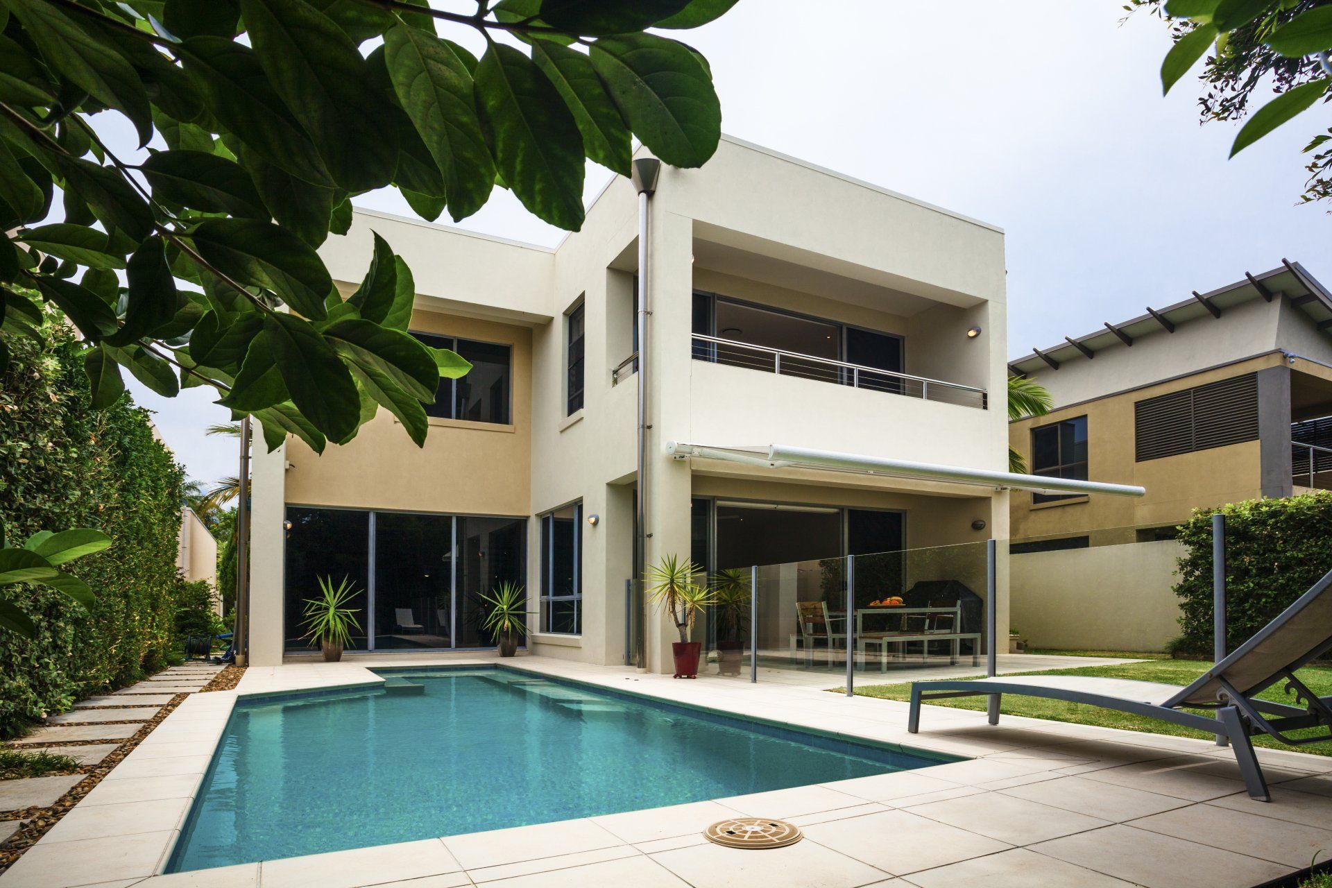 patio chair next to rectangular pool and large beige appartment building