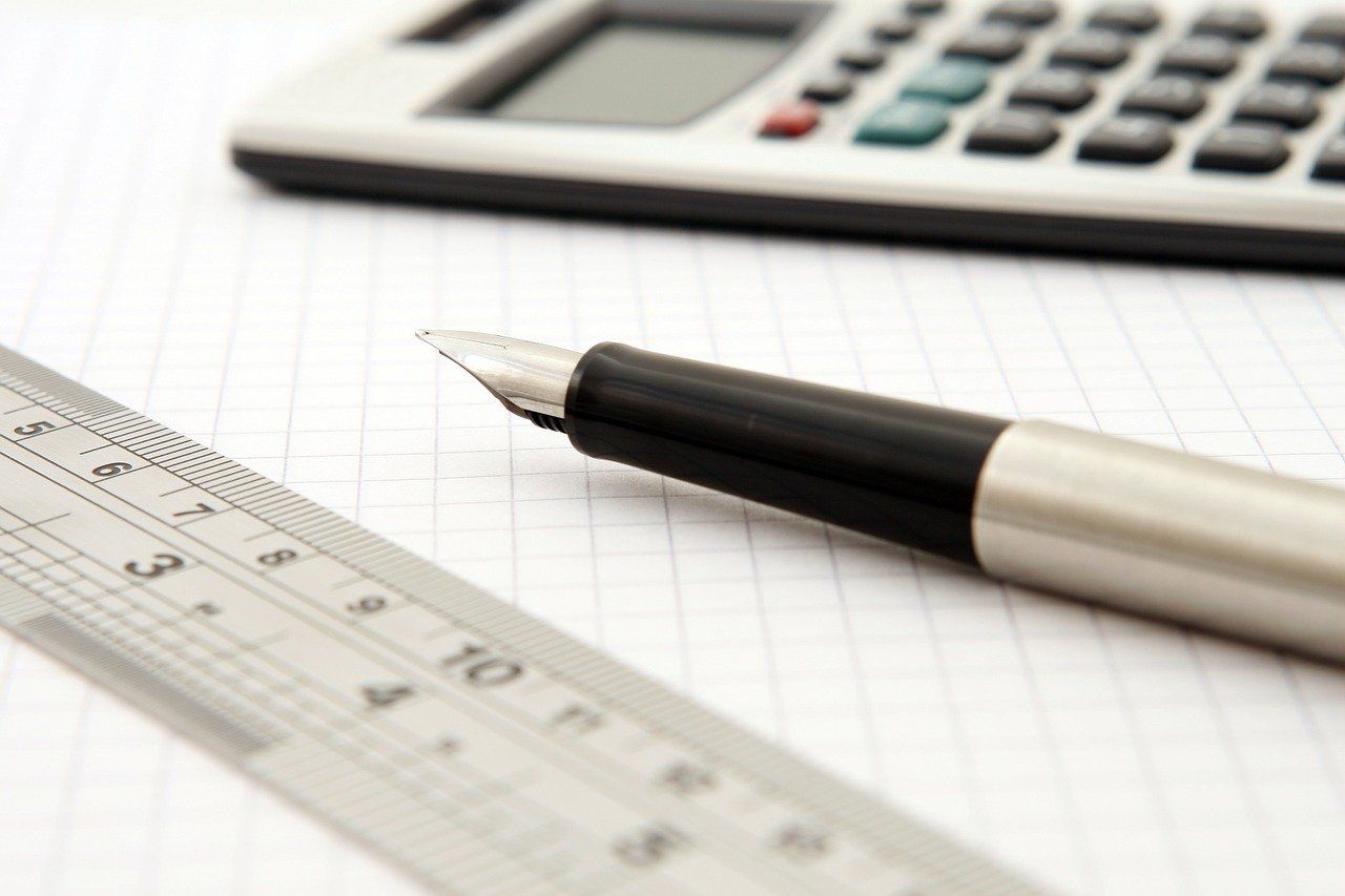 calculator, pen and ruler on a piece of graph paper