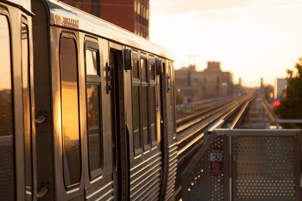 A subway train leaves the station into the dawn light.