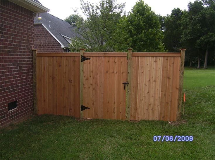 Exterior Brick Wall With Wooden Fence — Madison, TN — Music City Fence Company