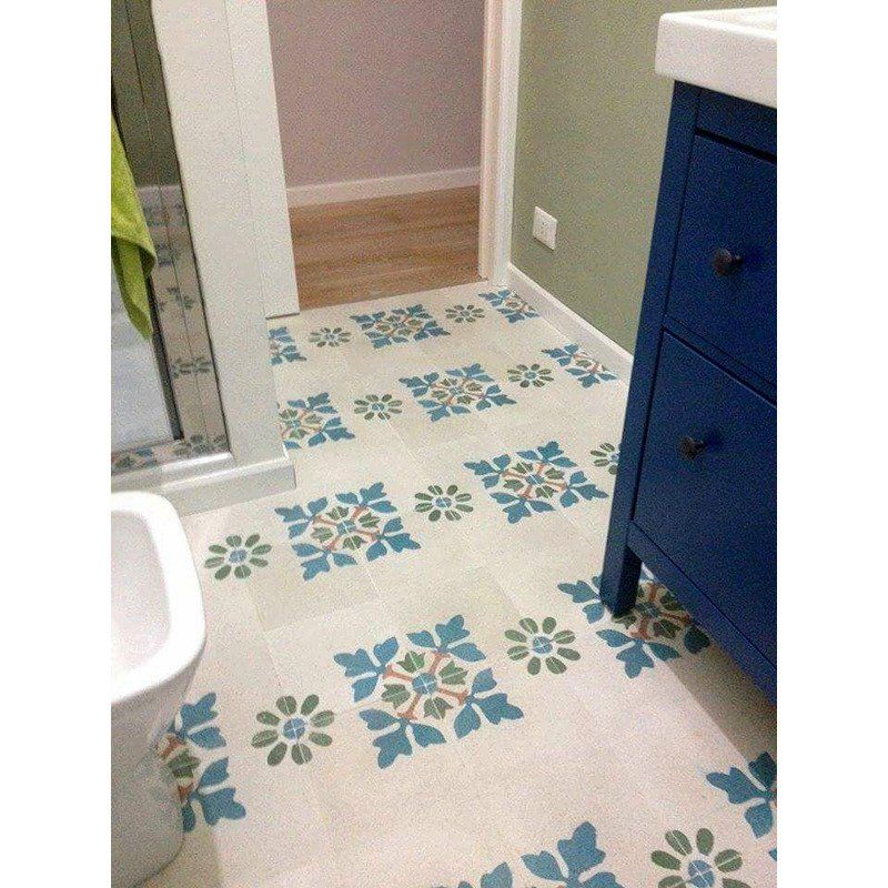 un bagno con delle piastrelle di color bianco e deii disegni ai fiori azzurri