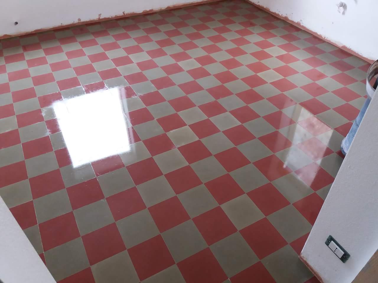 un pavimento a scacchi di color grigio e rosso