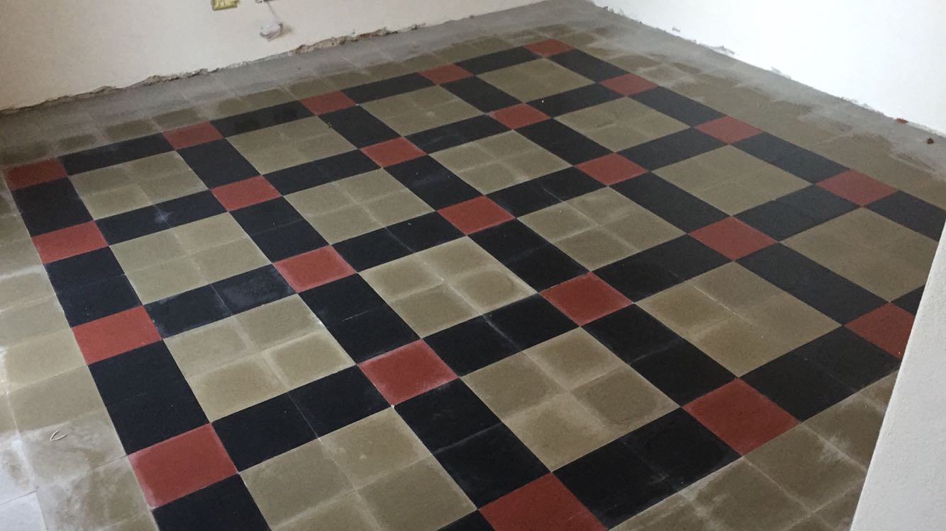 delle piastrelle a scacchi di color grigio, rosso e nero