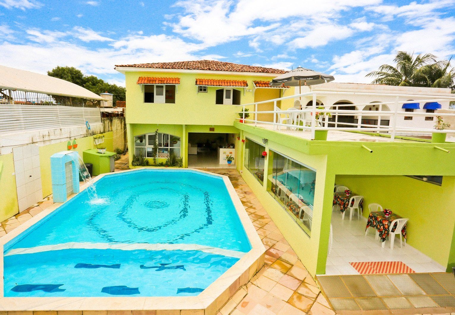 Uma grande piscina em frente a uma casa verde