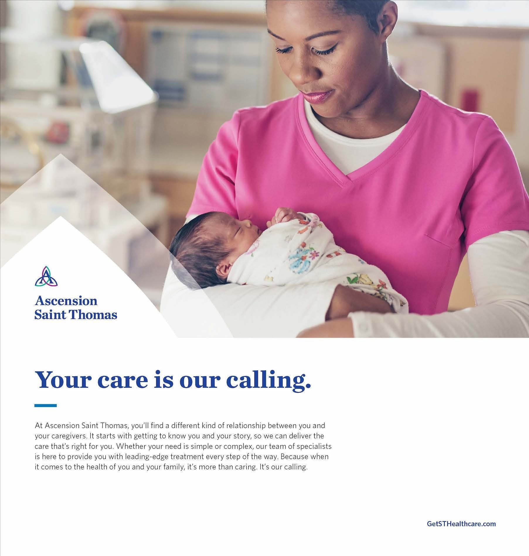 A nurse is holding a newborn baby in her arms.