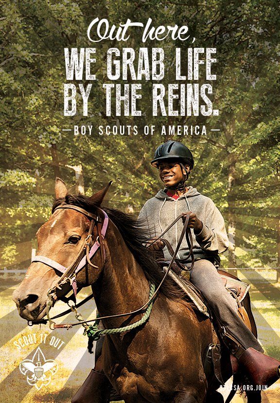 A boy scout is riding a horse on a poster that says `` out here , we grab life by the reins . ''