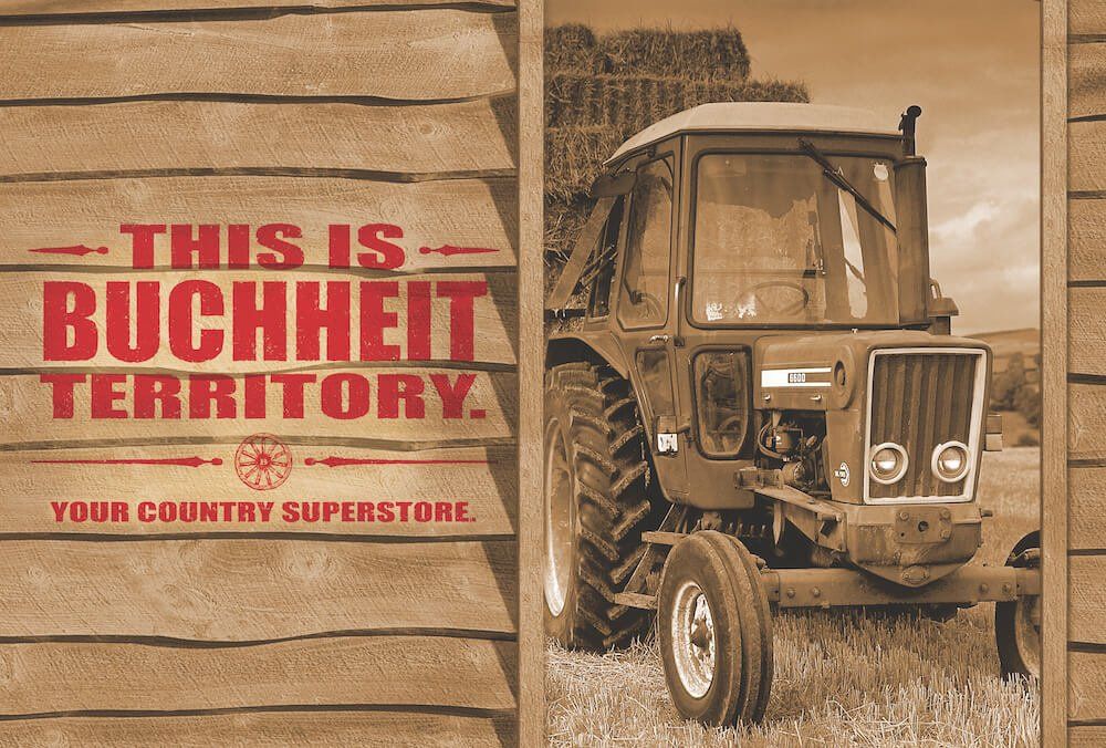A tractor is parked in front of a sign that says this is buchheit territory