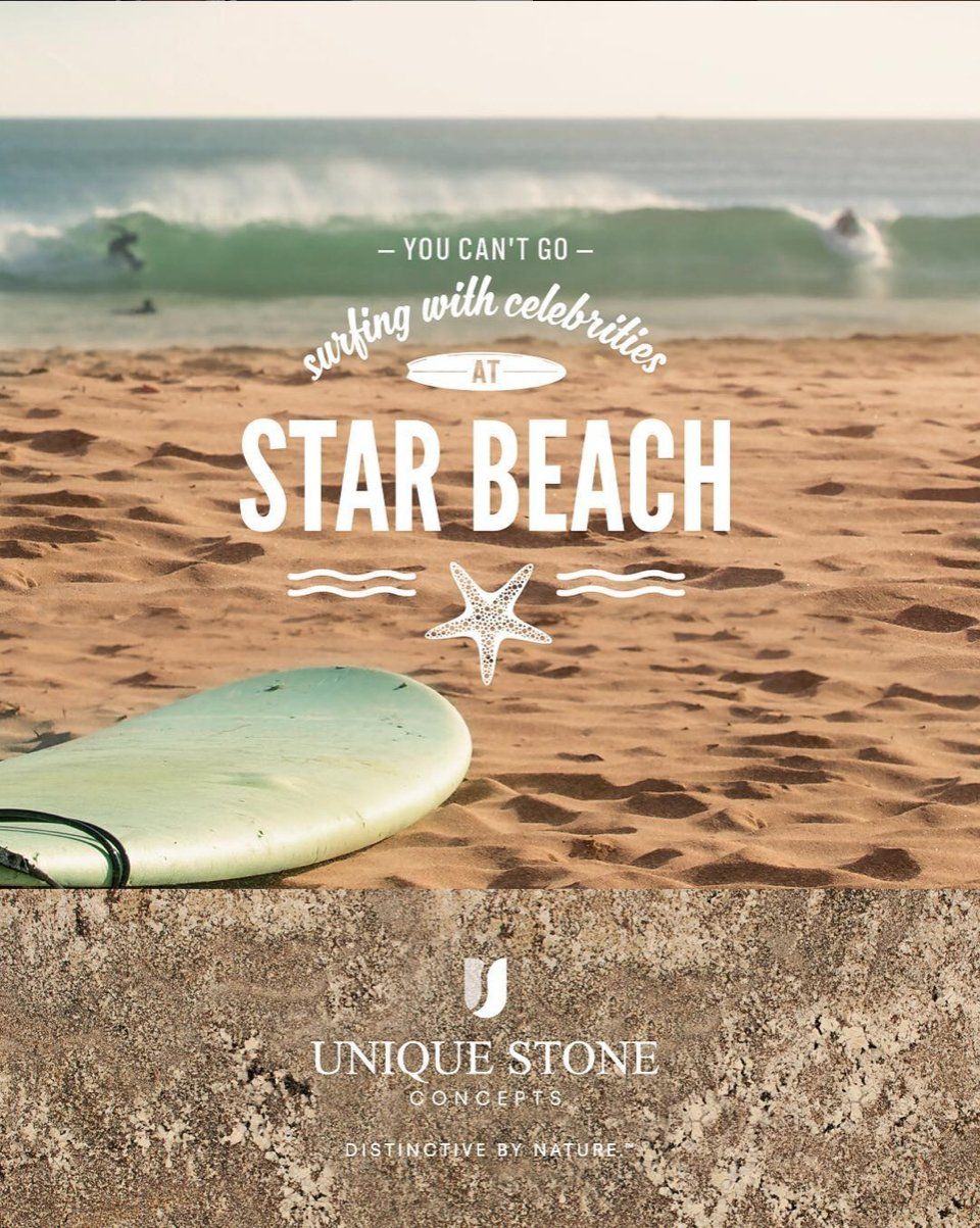 A surfboard is laying on the sand on a beach.